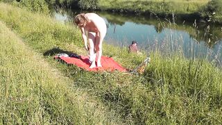 Riverside exposed milf sunbathing is not shy about random fisher. Outdoors. Wild beach. Public nudity