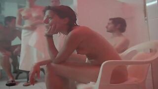 Undressed woman is having a great time in the sauna with undressed people she has just met